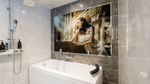 A modern bathroom with a large mirror, a bathtub, and a shower. - Theban Hotel (Chungju)