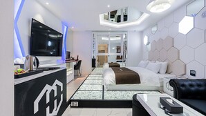A modern hotel room with a large bed, a TV, a desk, and a seating area. - Theban Hotel (Chungju)