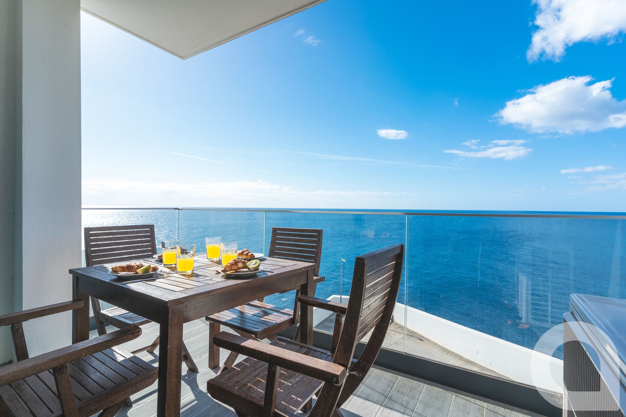 Ein Balkon mit Frühstückstisch und Blick auf das Meer.