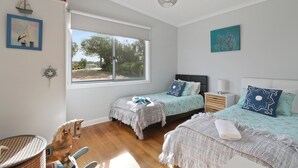 Une chambre avec deux lits, une fenêtre et une vue sur l’extérieur.
