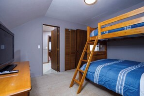A bunk bed with a ladder, a desk with a remote control, and a television. There are wooden doors and a closet in the background. - 185' Waterfront Sand Bay Owl's Nest 4BR sleeps 9 (Sturgeon Bay)