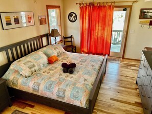 Une chambre à coucher avec un lit, une chaise, une commode et une fenêtre avec des rideaux.