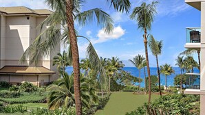 A resort with a pool, palm trees, and a view of the ocean.