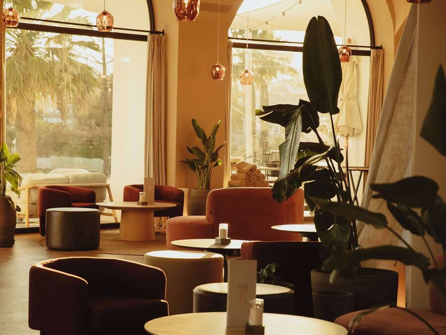A modern interior with arched windows, a round coffee table, and several seating areas.