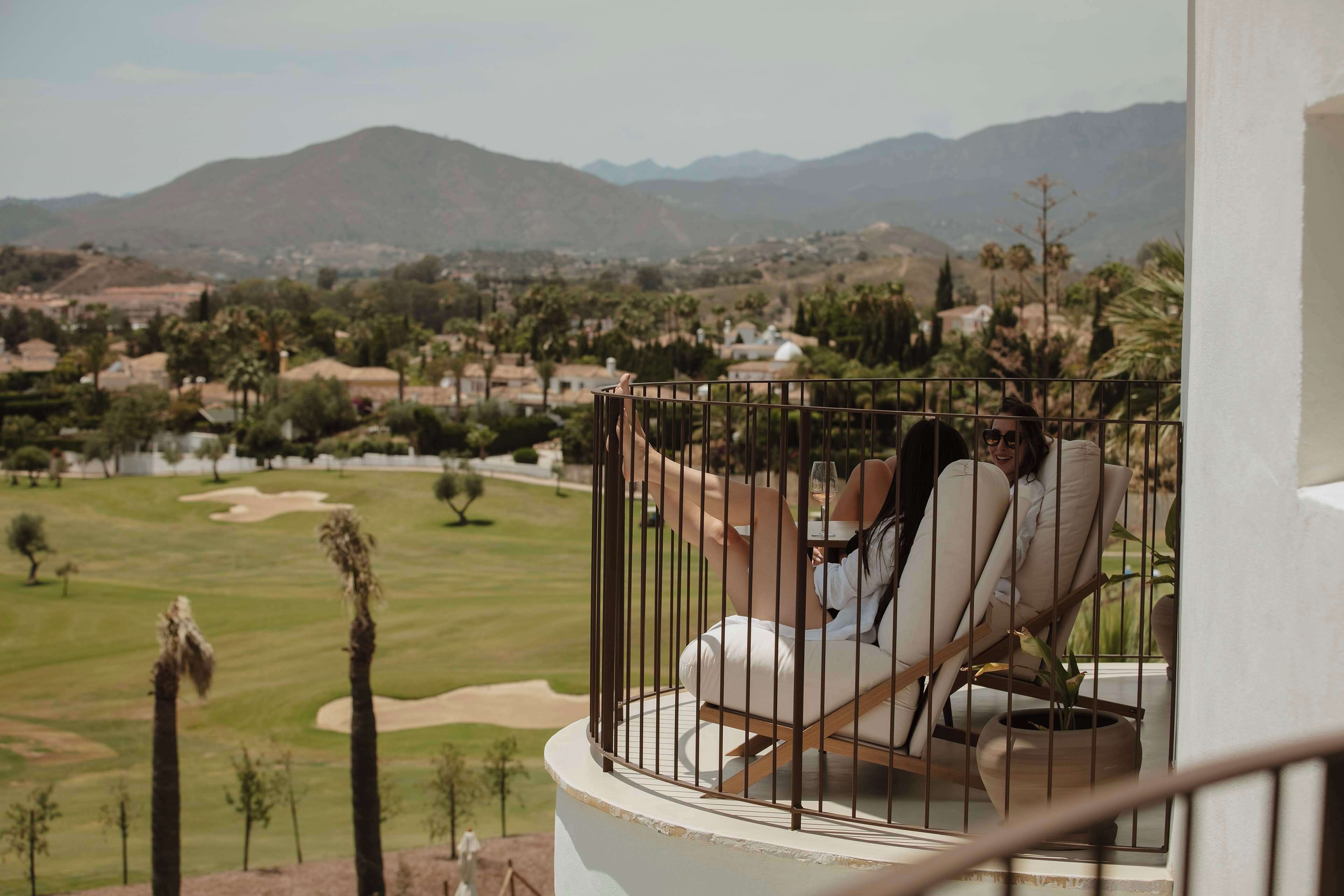 Un balcón con vistas a un campo de golf y montañas.
