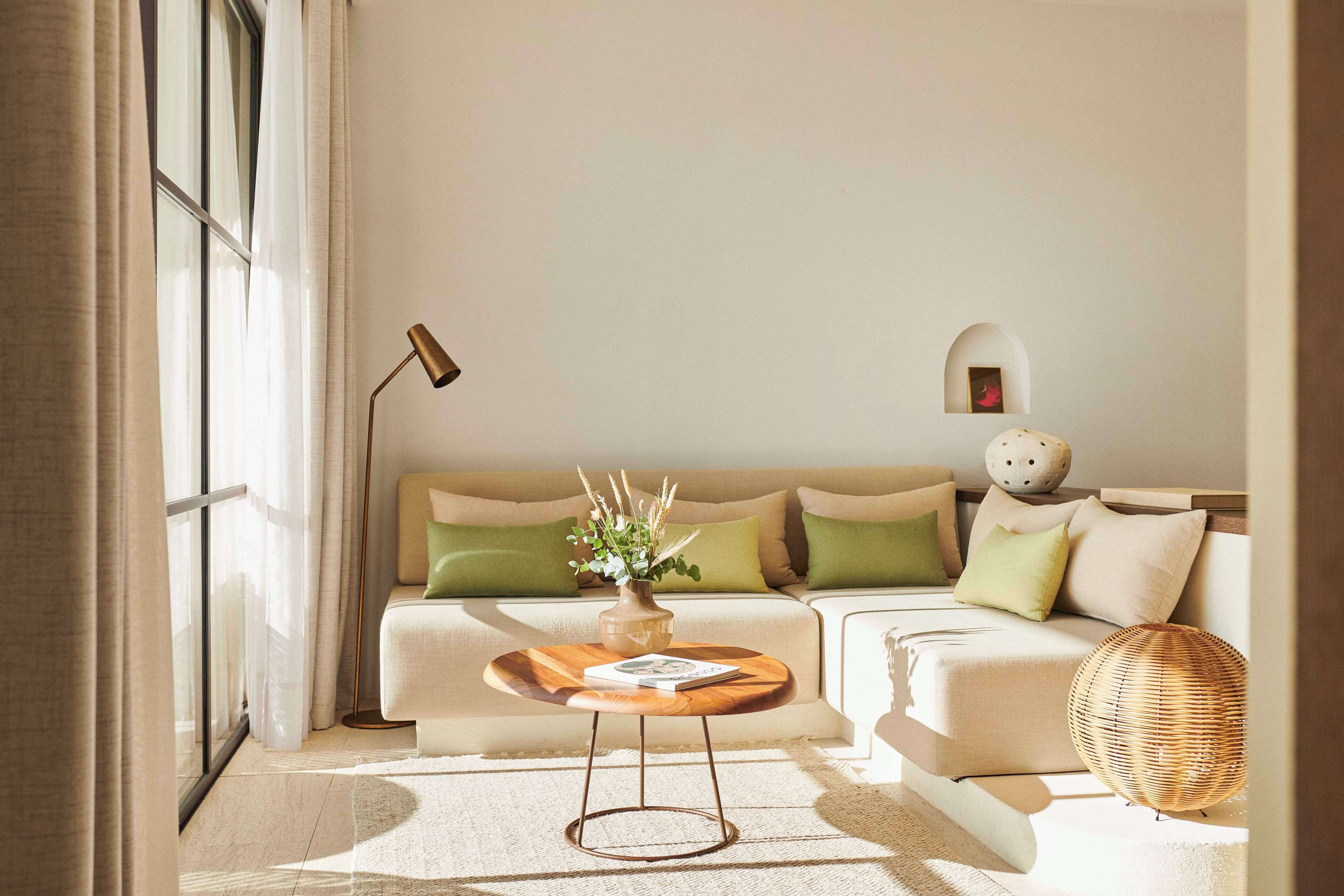 Ein modernes Wohnzimmer mit einer Couch, einem runden Holztisch und einer Stehlampe.