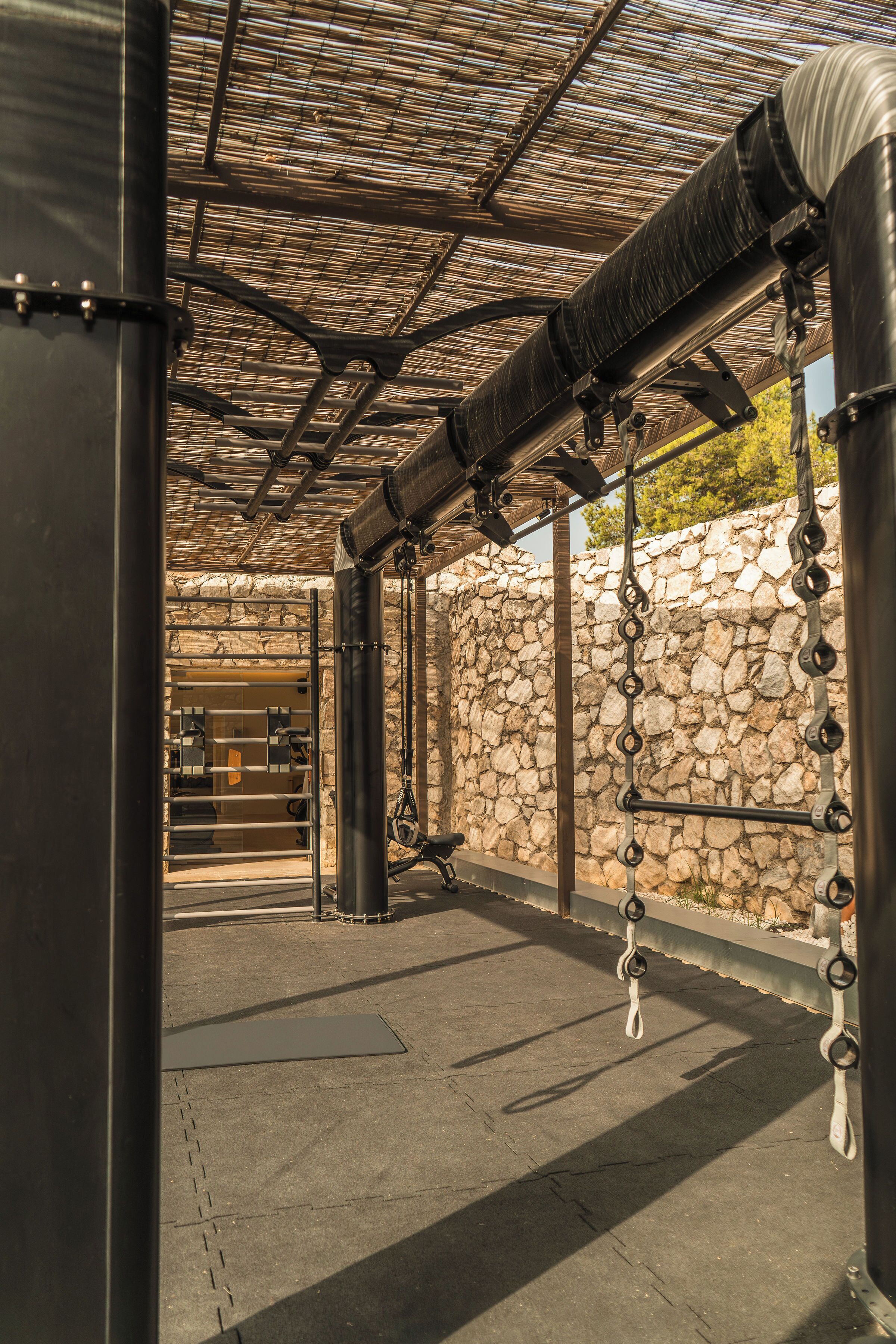 A covered outdoor area with stone walls and metal structures.