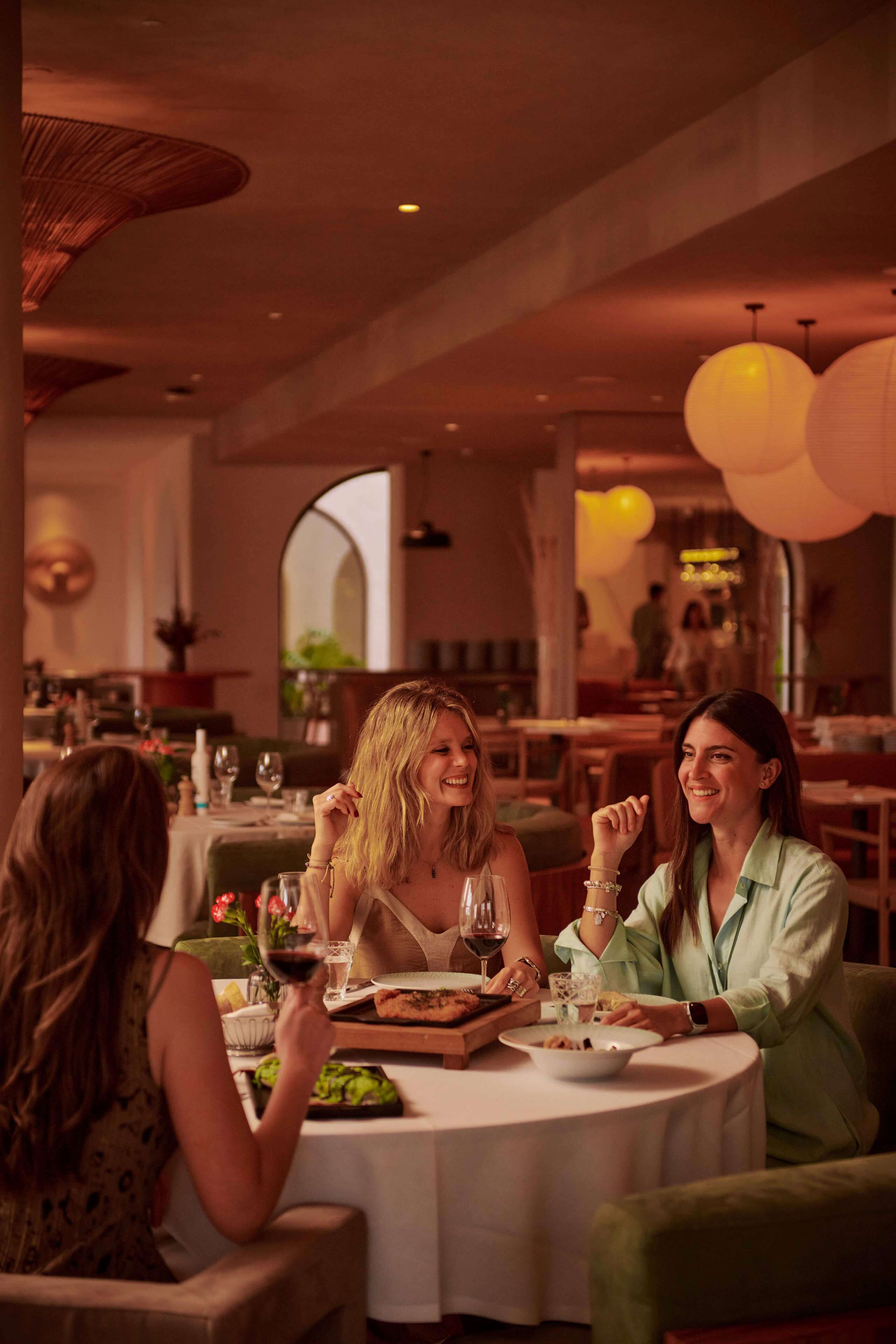 A dining area with round tables, chairs, and a warm ambiance.