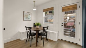 A dining area with a table and chairs, a potted plant, a hanging light fixture, and a door with a view of an outdoor patio. - Modern Farmhouse in the Heart of San Diego (San Diego)