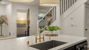 A modern kitchen with a large island, stainless steel appliances, and a view of the living area. - Modern Farmhouse in the Heart of San Diego (San Diego)
