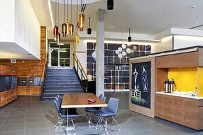 Stunning interior space with a central staircase, dining area, and kitchenette.