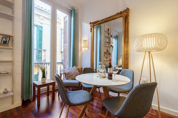 A dining area with a round table, chairs, a mirror, and a floor lamp.