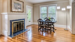 A dining area with a fireplace, a table with chairs, and a window with blinds. - Walk to Historic District & Shops, Close to Beach, Free Driveway Parking, $300 in Free Tickets! (St. Augustine)