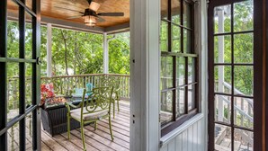 A covered porch with a ceiling fan, a wicker chair, and a table with a fire feature. - Walk to Historic District & Shops, Close to Beach, Free Driveway Parking, $300 in Free Tickets! (St. Augustine)