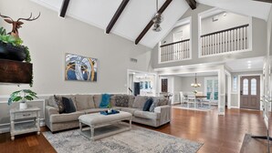 A spacious living area with a high ceiling, a dining area, and a staircase leading to an upper level. - Four bedroom  in United States of America, Tomball (Tomball)
