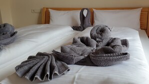 A neatly made bed with white linens and multiple gray towels arranged in a decorative manner. - Vacation home Blindauer Eck 160 sqm with mountain view (Reit im Winkl)