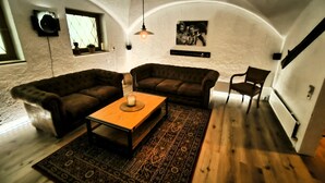 A cozy living room with a wooden coffee table, two sofas, a patterned rug, and a painting on the wall. - Vacation home Blindauer Eck 160 sqm with mountain view (Reit im Winkl)