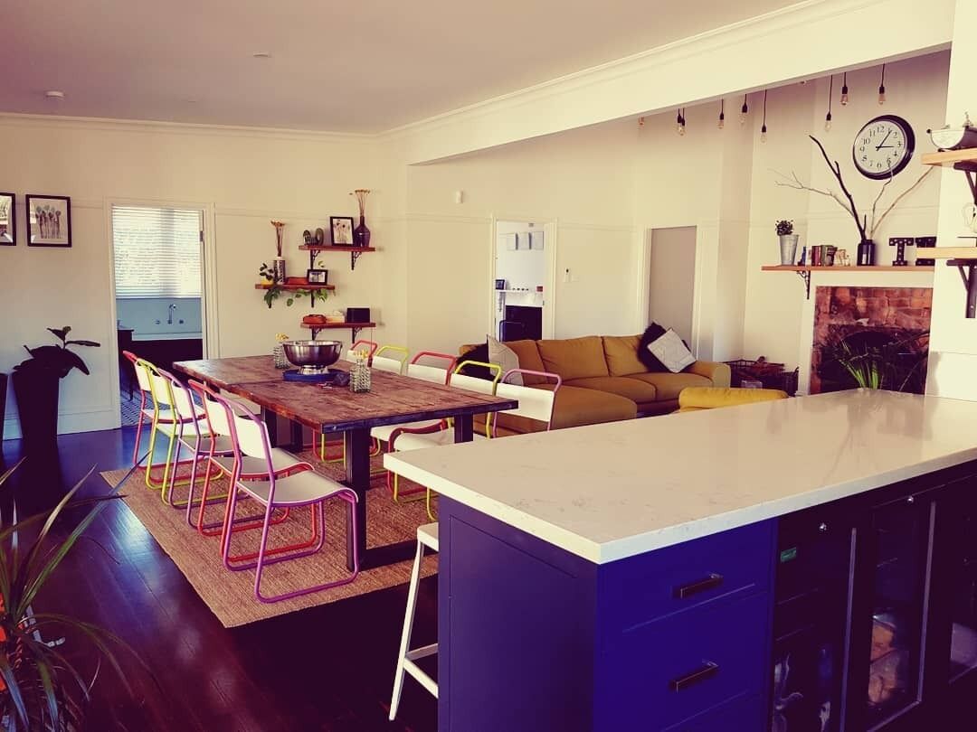 Una cocina moderna con comedor, sofá y chimenea.