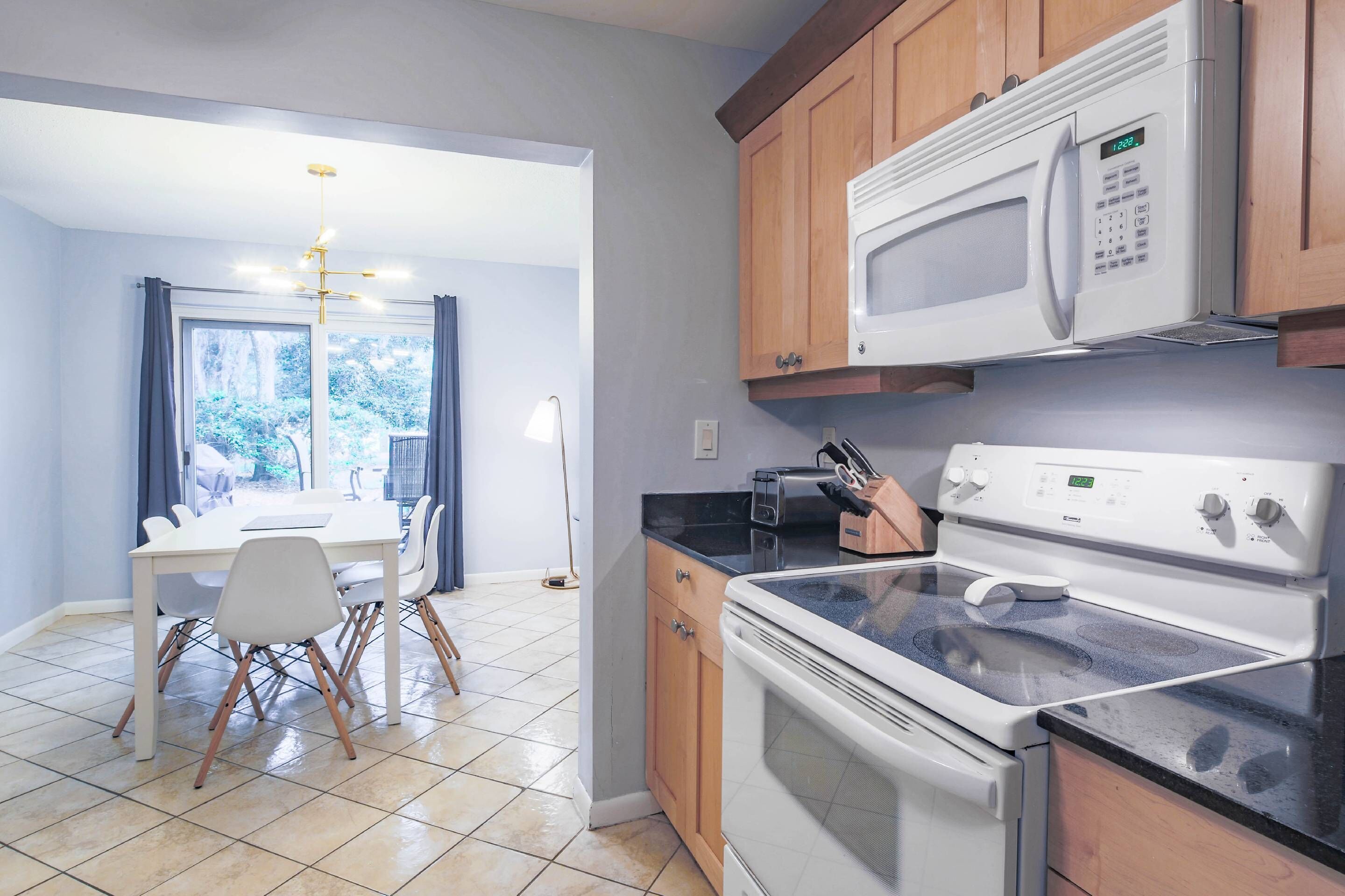 Une cuisine moderne équipée d’un four à micro-ondes, d’une cuisinière et d’un coin repas avec une table et des chaises.