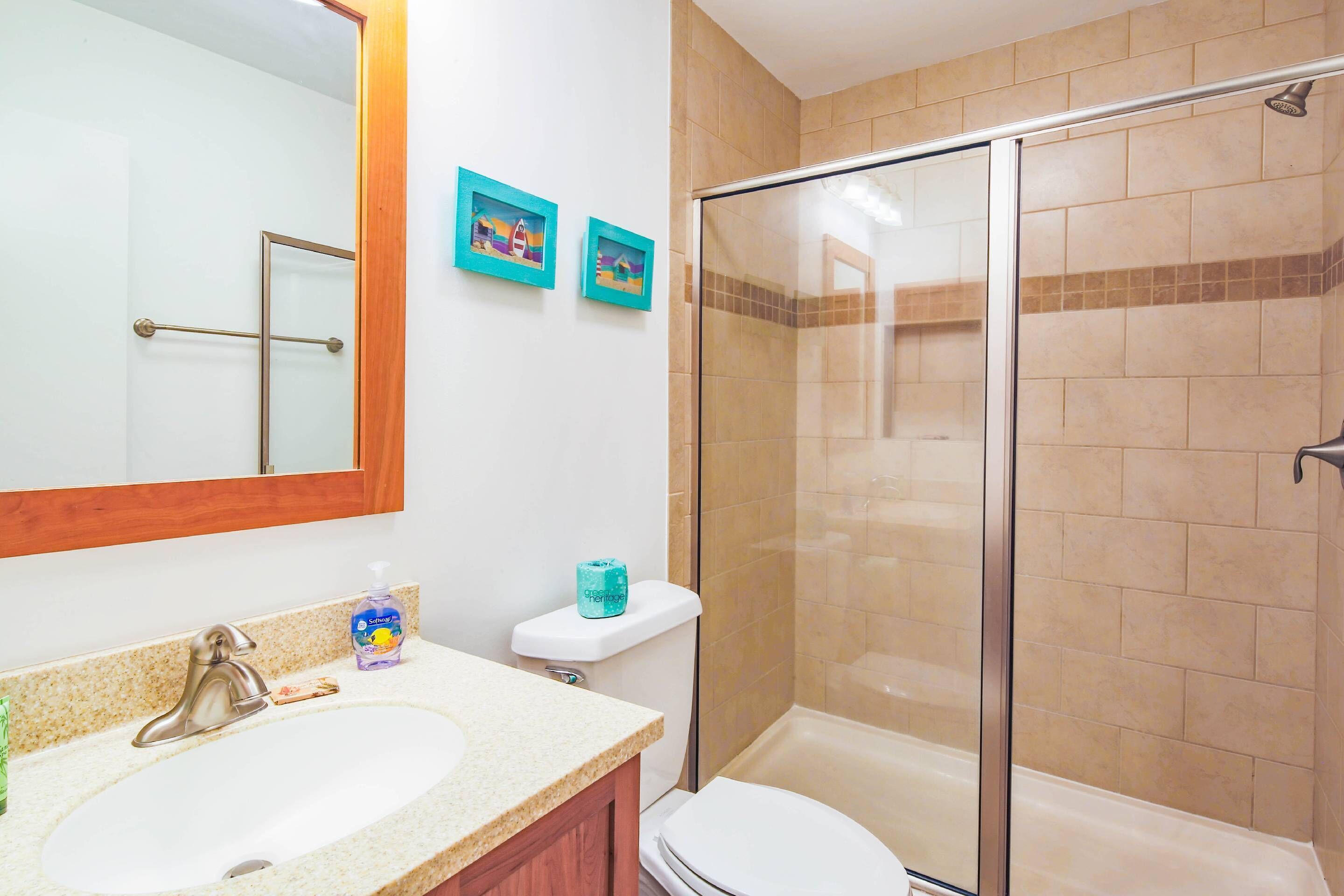 Un bagno con lavandino, WC e cabina doccia in vetro.