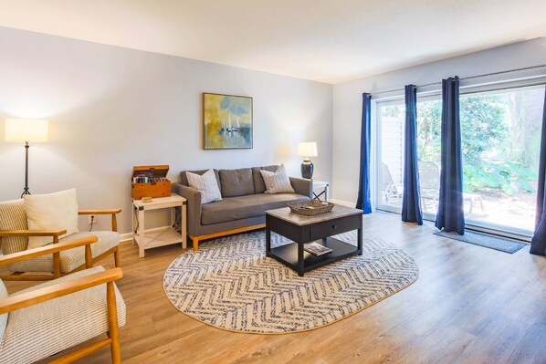 Ein Wohnzimmer mit einer Couch, Sesseln, einem Couchtisch und einem Bild an der Wand.