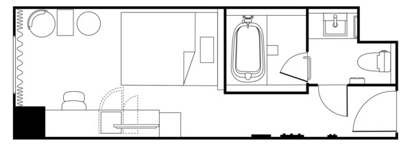 Un plan d’étage d’une chambre d’hôtel comprenant un lit, un bureau, une chaise et une salle de bain avec des toilettes, un lavabo et une douche.
