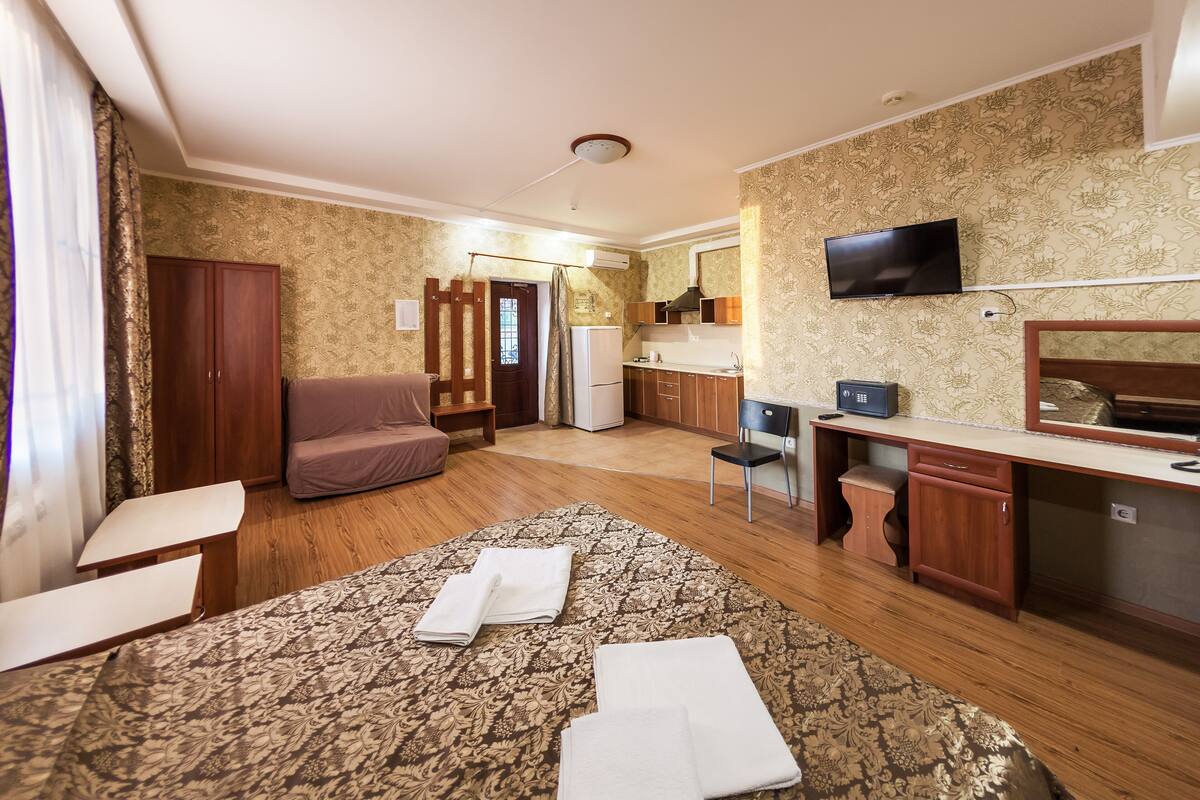 Relax in this well-appointed room with a large bed, sofa, and kitchenette.