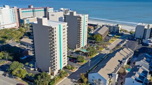 Un grand hôtel à plusieurs étages, doté d’un parking et offrant une vue sur la plage.