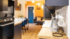 A modern kitchen with a wooden countertop, a coffee machine, and a kettle. - 7 bed house| Sleeps 14 | ENSUITE |Free HS WIFI | TVs in rooms | CITY CENTRE | Inspire Homes (Coventry)