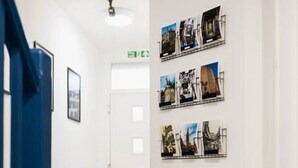 A hallway with a patterned floor, a blue door, and a wall with framed pictures. - 7 bed house| Sleeps 14 | ENSUITE |Free HS WIFI | TVs in rooms | CITY CENTRE | Inspire Homes (Coventry)