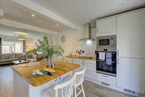 Enjoy cooking in this well-equipped kitchen with a central island, sink, and stainless steel appliances.