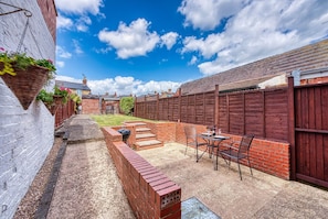Enjoy outdoor dining and relaxation in this patio area with a grill and seating for al fresco meals.