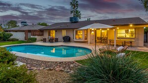 A modern house with a swimming pool, patio, and a covered outdoor dining area. - Single-Level 3BR Scottsdale Home | Pool Table, Fire Pit (Scottsdale)