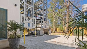 A multi-story parking structure with cars parked on different levels. - The Iris, Signature Suite (Charleston)