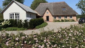 A two-story house with a white exterior and a thatched roof. - Reet Kate|3SZ|Sauna|Garding in St. Peter-Ording (Garding, Kirchspiel)