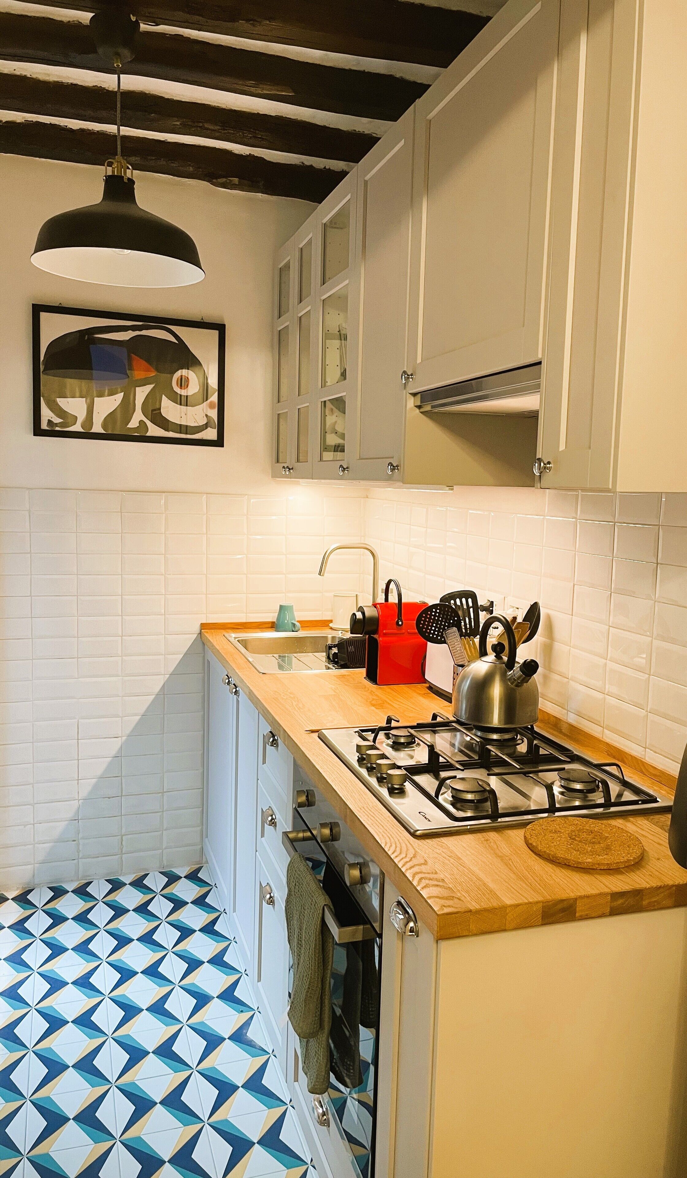 A kitchen with a gas stove, a sink, and cabinets.