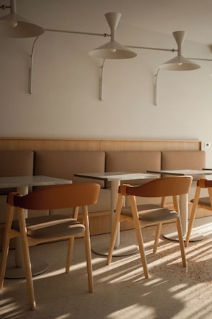 A dining area with a booth seating arrangement and individual tables. - Laguna Faro Suites - Adults Only & Free Beach (Grado)