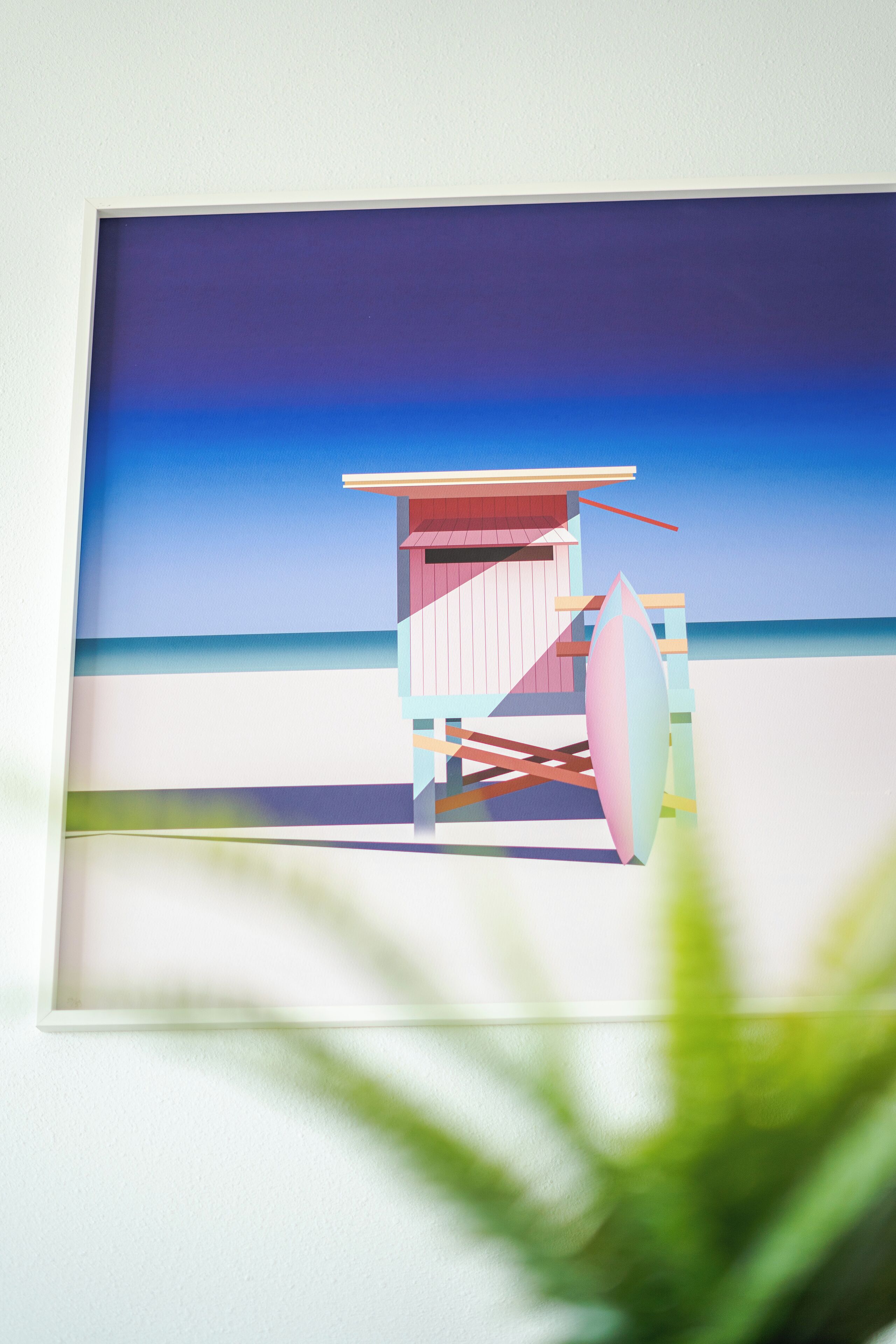 A beach hut with a surfboard leaning against it.