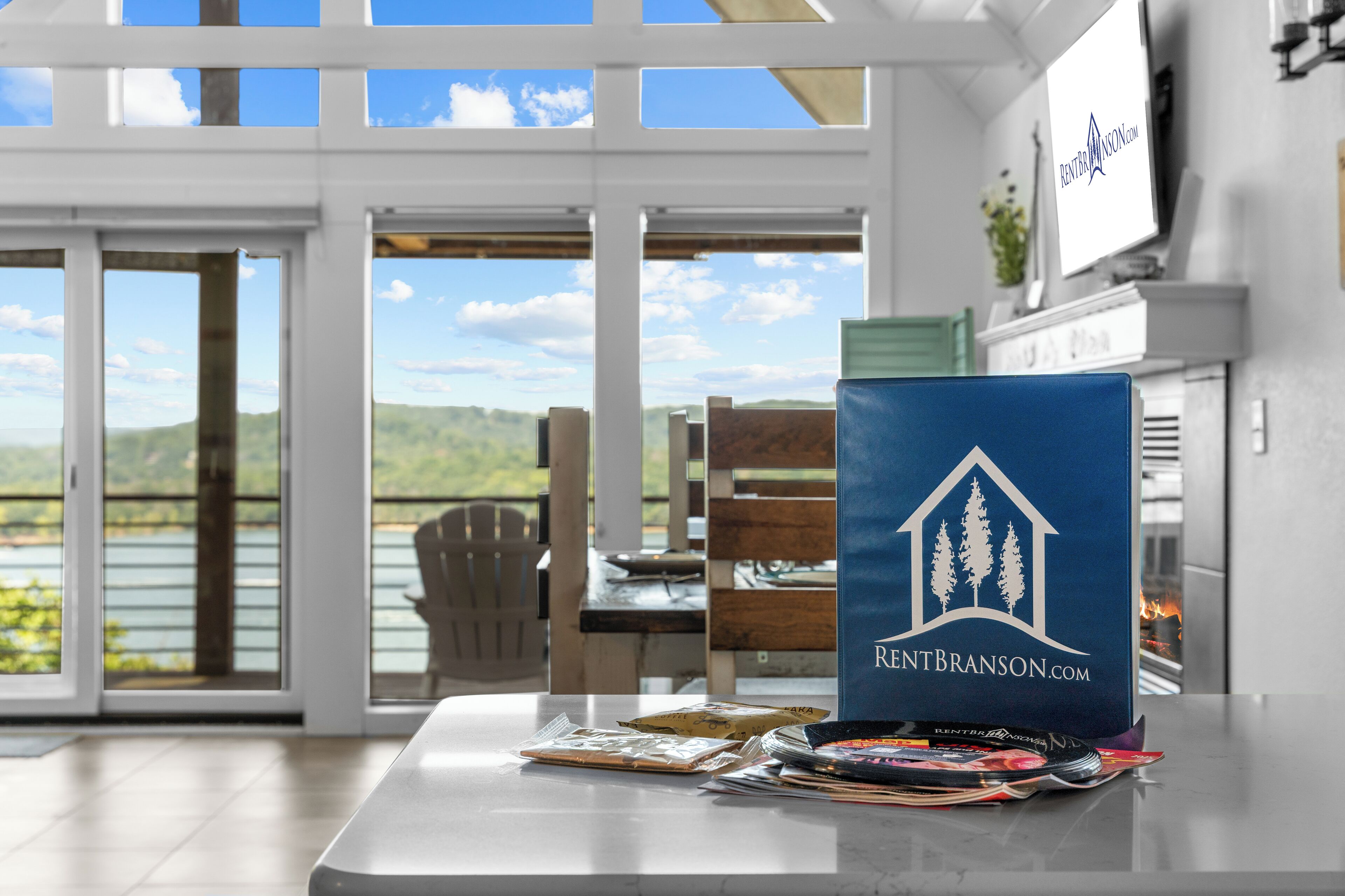 Eine Küche mit Seeblick, eine blaue Ordner mit einem Hauslogo und Zeitschriften auf der Arbeitsfläche.