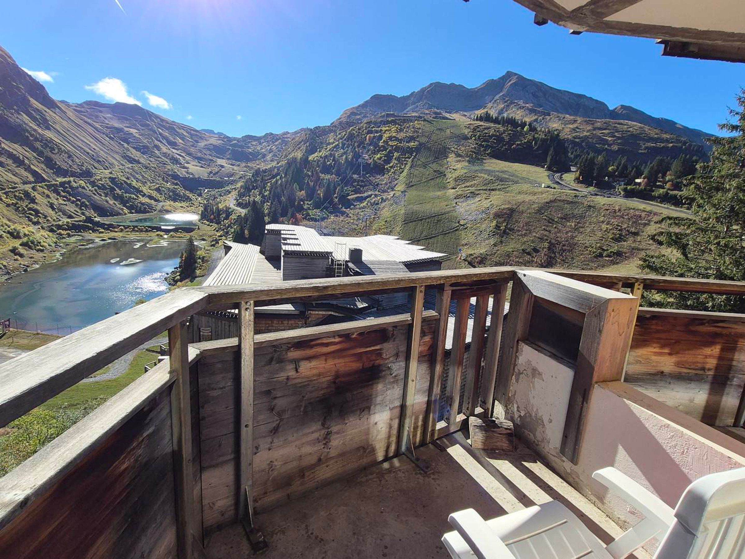 A wooden deck with a view of a river and mountains.