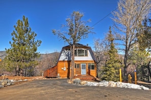A cabin with a wooden exterior, a front porch, and a clear sky. - Clouds Rest Cabin by Destination Big Bear: Tranquil Secluded Setting with Ski Slope Views! Close to Hiking Trails! Foosball! (Big Bear City)
