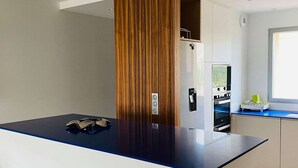 A modern kitchen with a central island, built-in appliances, and a window providing natural light. - 3-room apartment, 2 beds, beach, parking, AC, WiFi (Calvi)
