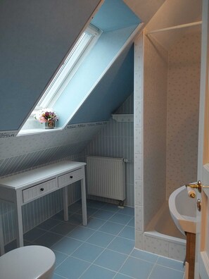 A small, compact bathroom with a skylight, a white vanity, a toilet, and a bathtub. - Apartment Pine View - Apartment (Trassenheide)