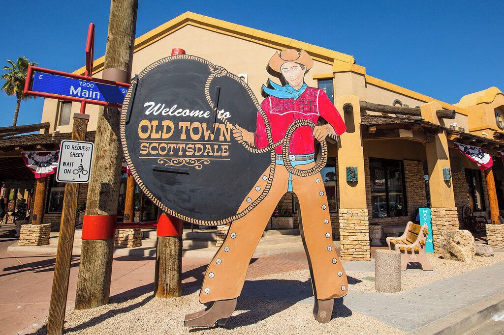 Un letrero de bienvenida a Old Town Scottsdale con la figura de un vaquero.