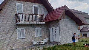 A two-story house with a balcony, a small attached garage, and a lawn. - Remarkable 3-bed House in Zabljak (Žabljak)