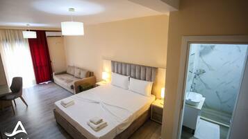 Una habitación de hotel con cama, sofá, escritorio y baño.