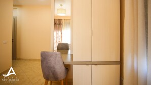 A hotel room with a dining table, a chair, a mirror, and a wardrobe. - New Akileda Hotel (Golem)