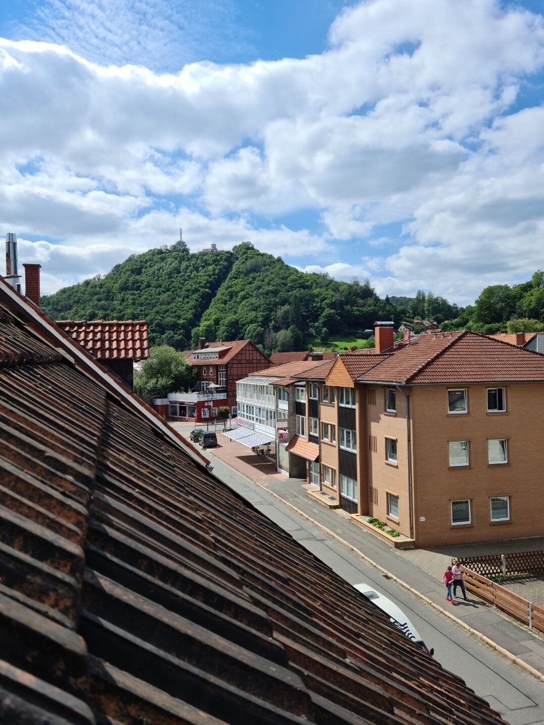 A town with terraced houses, a railway track, and a hill in the background.