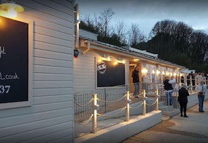 A building with a sign reading "The Hut" and a website address "ll.co.uk". - Freshwater - Hot Tub - Pet Friendly - Garden (Freshwater)