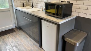 A compact kitchen with a microwave, sink, and dishwasher. - Freshwater - Hot Tub - Pet Friendly - Garden (Freshwater)